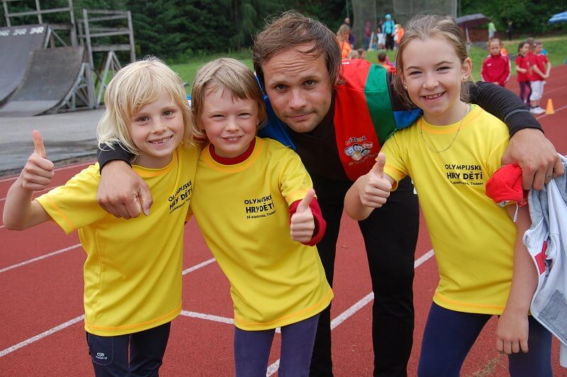 Olympijské hry dětí Trutnovských škol. Učitel a tři olympijské běžkyně ze ZŠ Mládežnická ve svých školních, olympijských tričkách.