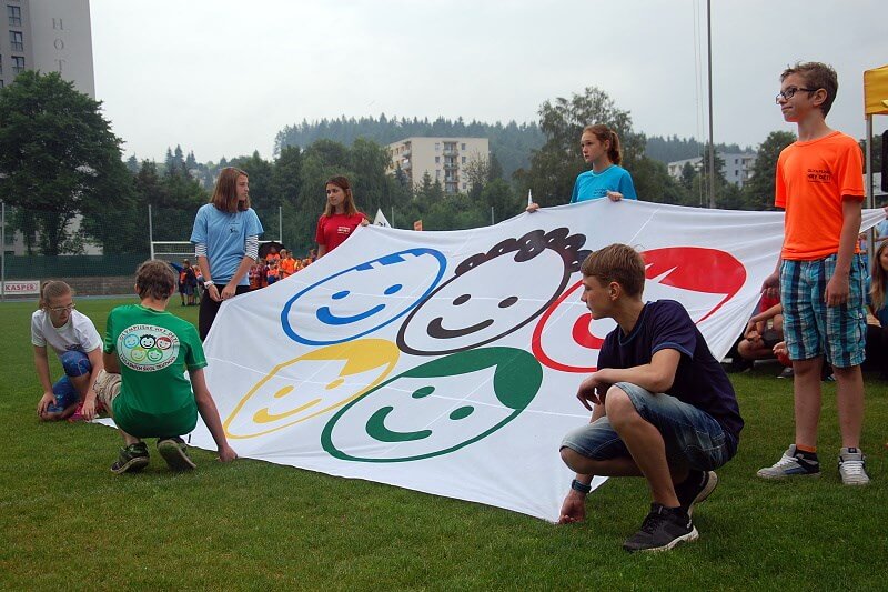 Olympijské hry dětí Trutnovských škol. Úvodní ceremoniál. Vybraní žáci drží olympijskou vlajku.