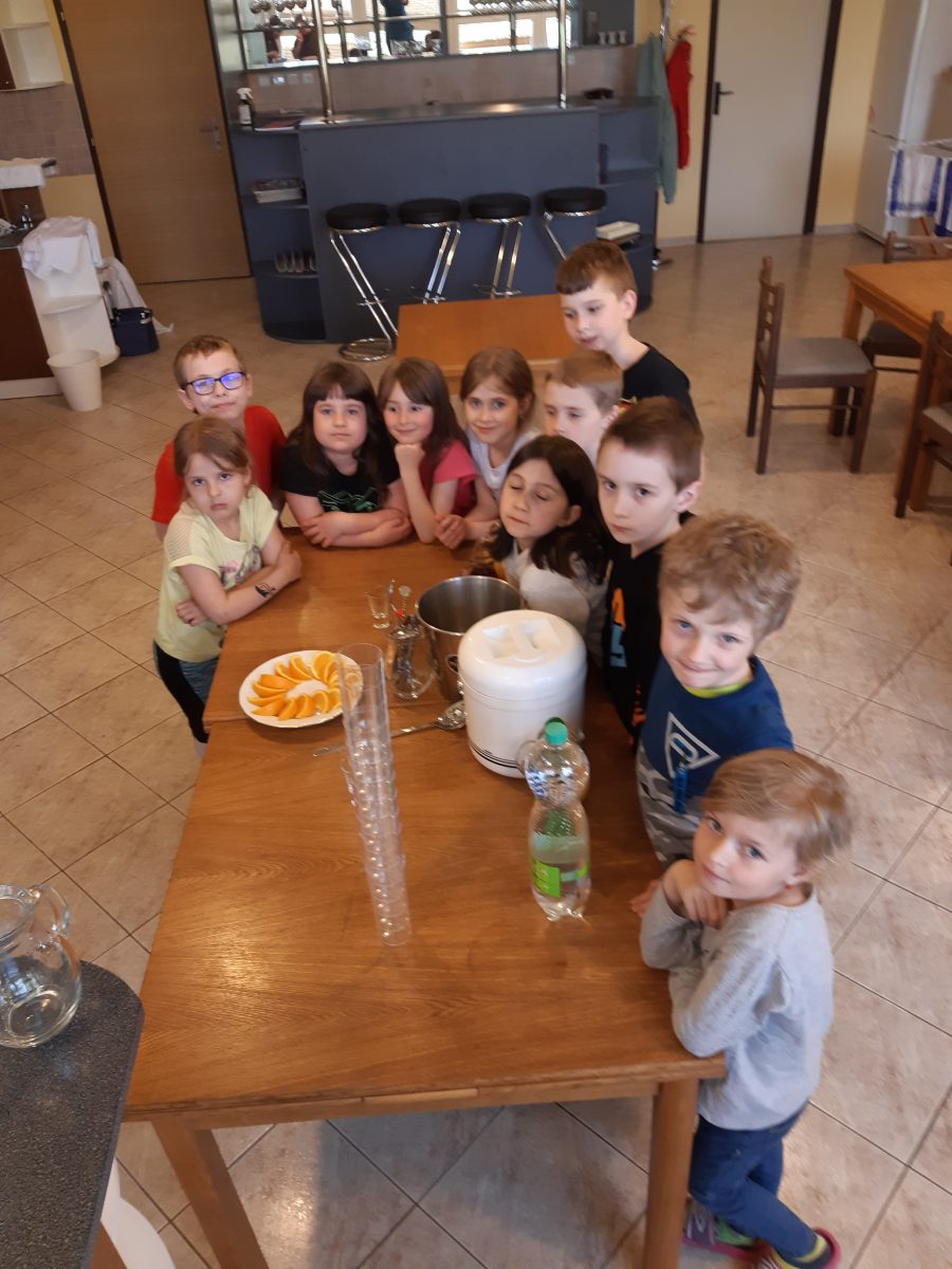 Stojící děti u stolu s dobrotami.