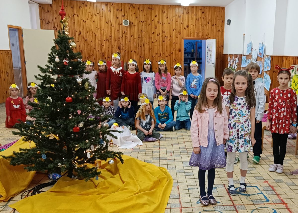 Děti stojí u vánočního stromečku